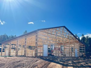 A building under construction rises under a blue sky, showcasing the growth and potential of shop Douglas County.
