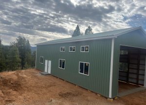 A building under construction with trees and clouds in the background